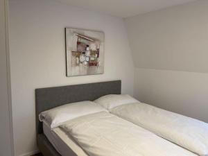 uma cama num quarto com uma fotografia na parede em Schlossappartement Rapperswil em Rapperswil-Jona