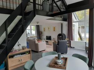 - un salon avec un escalier en colimaçon dans l'établissement Vrijstaande recreatievilla met ruime omheinde tuin, à Posterholt