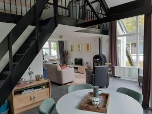 een woonkamer met een wenteltrap en een woonkamer bij Vrijstaande recreatievilla met ruime omheinde tuin in Posterholt