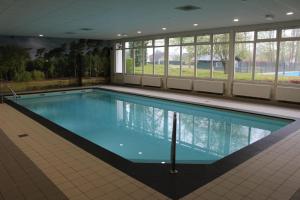 - une grande piscine dans un grand bâtiment dans l'établissement Vrijstaande recreatievilla met ruime omheinde tuin, à Posterholt