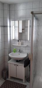 a bathroom with a sink and a mirror at Ferienhaus Luetje-Huuske in Krummhörn