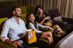 a group of people sitting on a couch with drinks at The Embassy Valletta Hotel in Valletta