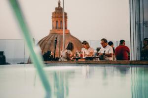 a group of people sitting at a table in a restaurant at The Embassy Valletta Hotel in Valletta