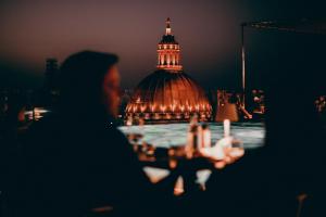 a person sitting at a table in front of a building at The Embassy Valletta Hotel in Valletta