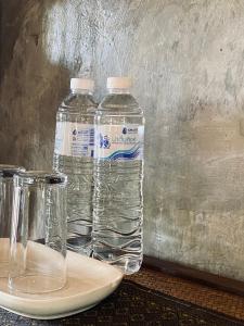 dos botellas de agua sentadas encima de un plato en Little Eden Guesthouse, en Pang Mapha