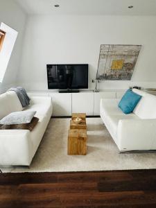 uma sala de estar com um sofá branco e uma mesa em Design Apartment em Berlim