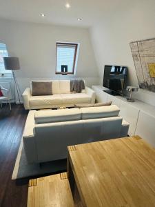 a living room with a couch and a tv at Design Apartment in Berlin