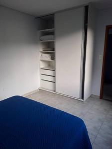 1 dormitorio con cama azul y armario en Freja I - Ciudad Cultural - Departamento entero con cochera en San Salvador de Jujuy
