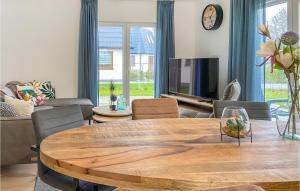 sala de estar con mesa de madera y TV en Kavel 12, en Den Oever