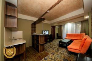 a living room with an orange couch and a table at Borjomi Palace Health & Spa Center in Borjomi