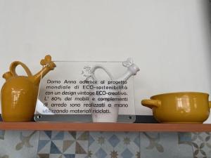 une étagère avec deux vases et un signe sur celle-ci dans l'établissement Domo Anna, à Villasimius