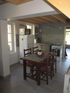 eine Küche mit einem Tisch und Stühlen sowie einem Kühlschrank in der Unterkunft Le Pavillon Tilia in Montrichard