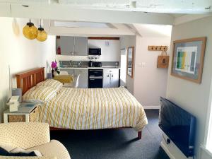 een woonkamer met een bed en een keuken bij Bracken's Retreat in Lostwithiel