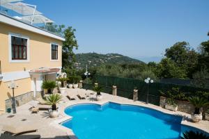 a swimming pool with chairs and a house at Resort Santangelo & SPA in Pimonte