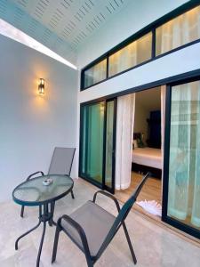 Ban Khlong HaengにあるBlue Ba You Resortのテーブルと椅子付きの部屋、ベッドルーム付きの部屋