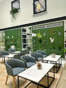 a restaurant with tables and chairs and a green wall at The Embassy Valletta Hotel in Valletta