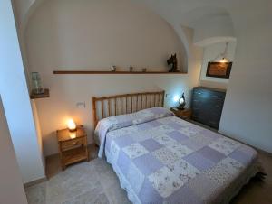 a bedroom with a bed with a blue and white quilt at Le Due Macine in Ventimiglia