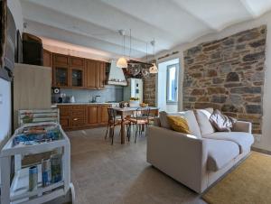 ein Wohnzimmer mit einem Sofa und einer Steinmauer in der Unterkunft Le Due Macine in Ventimiglia