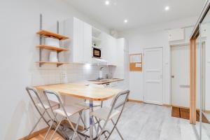 eine Küche mit einem Holztisch und Stühlen in der Unterkunft Orchid&Sakura studios Kamppi in Helsinki