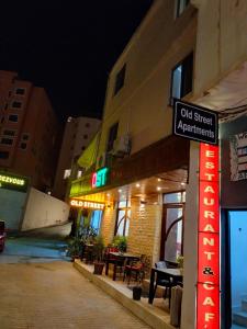 een bord aan de zijkant van een gebouw 's nachts bij Old Street Apartment in Wadi Musa