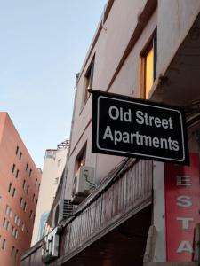 a sign for old street apartments on the side of a building at Old Street Apartment in Wadi Musa