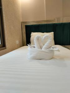 uma cama com dois cisnes feitos de toalhas em Old Street Apartment em Wadi Musa