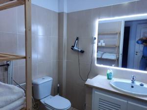 y baño con aseo, lavabo y espejo. en Apartamentos Turisticos Queluz en Queluz