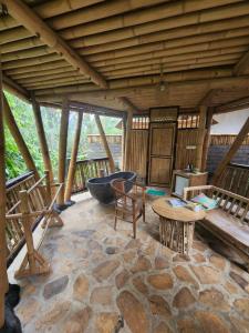 a large patio with a tub and a table and chairs at Pondok Salacca#bamboohouse# in Candidasa