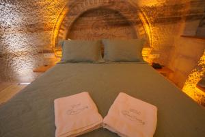 a bedroom with a bed with two towels on it at Göreme Cave Lodge in Göreme