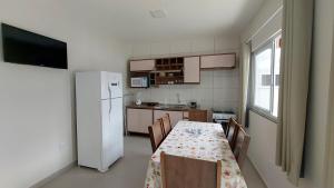 帕羅卡的住宿－1- MAHALO - Aloha Bratz Apartments，厨房配有桌子和白色冰箱。
