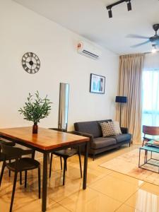 uma sala de estar com uma mesa e um sofá em Staycationbyrieymona - 3BR Condo, CLIO 2, Putrajaya em Putrajaya