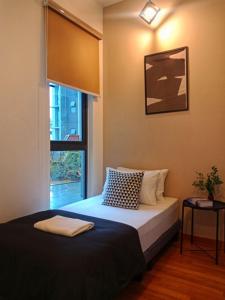 1 dormitorio con cama y ventana en Staycationbyrieymona - 3BR Condo, CLIO 2, Putrajaya en Putrajaya