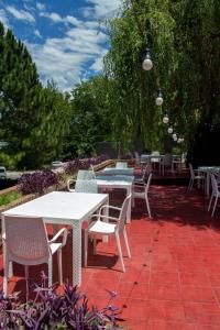 eine Gruppe von Tischen und Stühlen auf einer Terrasse in der Unterkunft Hotel Terrazas by CPH in Villa Carlos Paz