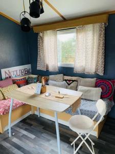 een kamer met een tafel en stoelen en een bed bij LA NOALHA INSOLIT' in Lanouaille