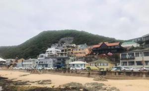 a group of houses on a beach next to a mountain at Apartment Ozone in Herolds Bay