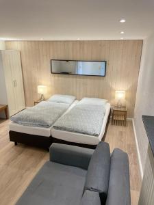 Un dormitorio con dos camas y un sofá. en Apartmenthaus Sonnen, en Düsseldorf