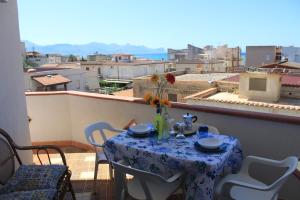 a table on a balcony with a view of a city at Dune Dorate,Tramonti Infiniti la tua oasi di pace in Dune ! Aprile al Mare in Appartamento con vista panoramica e WiFi Casa Vacanza Vista Mare in Sicilia Relax e Tramonti Unici in Alcamo Marina
