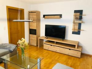 a living room with a television on a wooden entertainment center at Appartement Ariane in Frastanz
