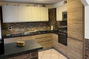 a kitchen with white cabinets and a sink at Casa Alexandra in Drena