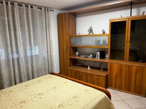 1 dormitorio con 1 cama y armario de madera en Casa Alexandra, en Drena
