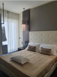 a bedroom with a large bed with a large window at Hotel Esplanade in Cesenatico