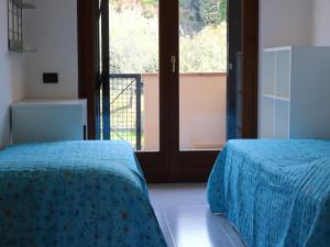 a bedroom with two beds and a large window at Apartment in Lazise with Lake View Balcony in Lazise