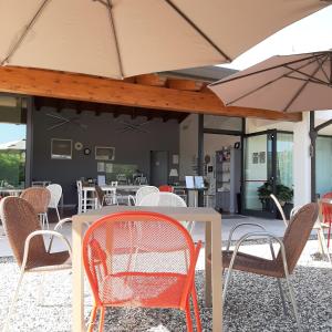 a table with chairs and an umbrella on a patio at Corte Mantovani in Colà di Lazise