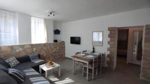 een woonkamer met een bank en een tafel bij Apartment Loparina in Nerezine