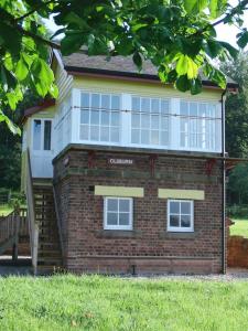 un edificio de ladrillo con una escalera delante de él en The Signal Box (Cliburn) en Penrith