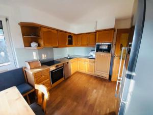 a small kitchen with wooden cabinets and a stove at Appartement Ariane in Frastanz