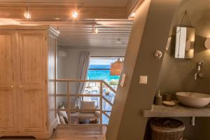a bathroom with a staircase leading to a room with a view at Onar Beach Houses in Amoopi