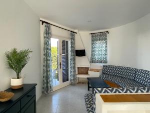 a living room with a couch and a table at Apartamentos Mar a mar in Cala en Forcat
