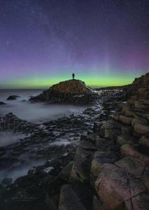 a person standing on top of a mountain under the stars at Hillside Luxury Bed & Breakfast in Ballycastle