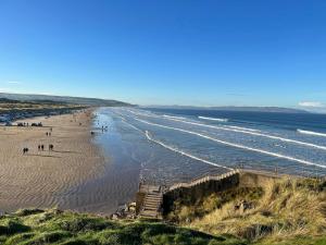 Blick auf den Strand mit Leuten darauf in der Unterkunft Hillside Luxury Bed & Breakfast in Ballycastle